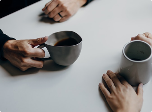 Two people with coffee cups in a personal conversation.